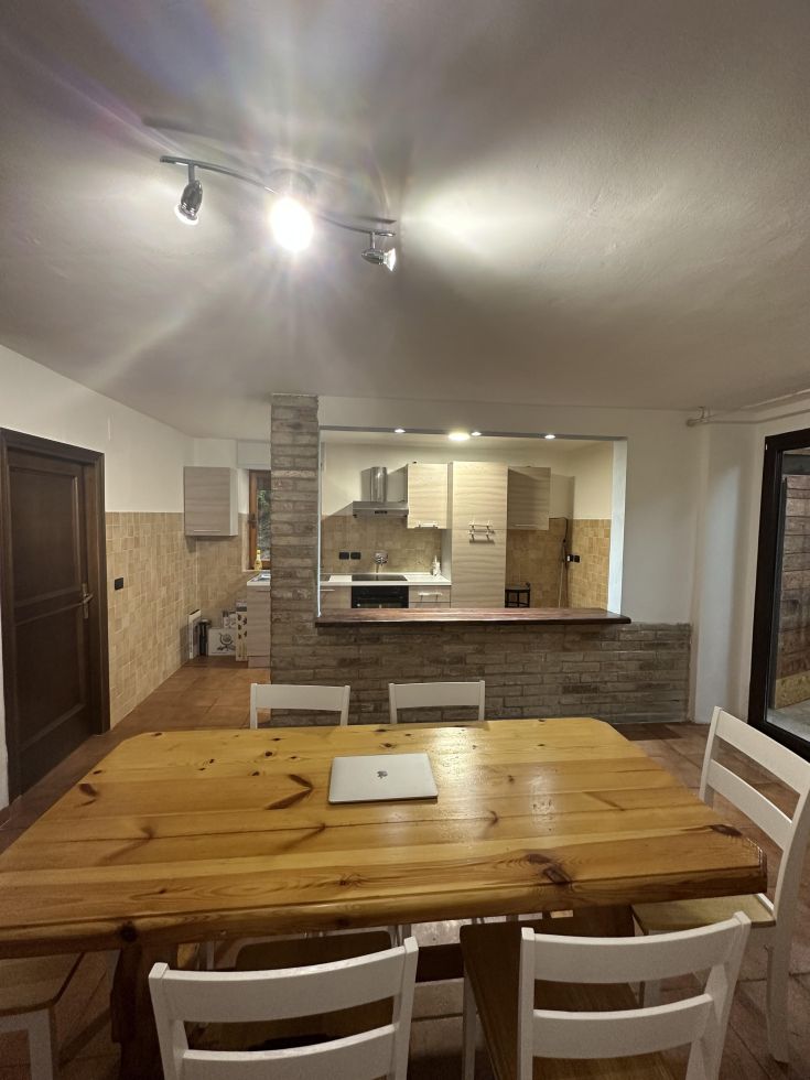 Spazio aperto che unisce cucina e sala da pranzo in un appartamento sereno.