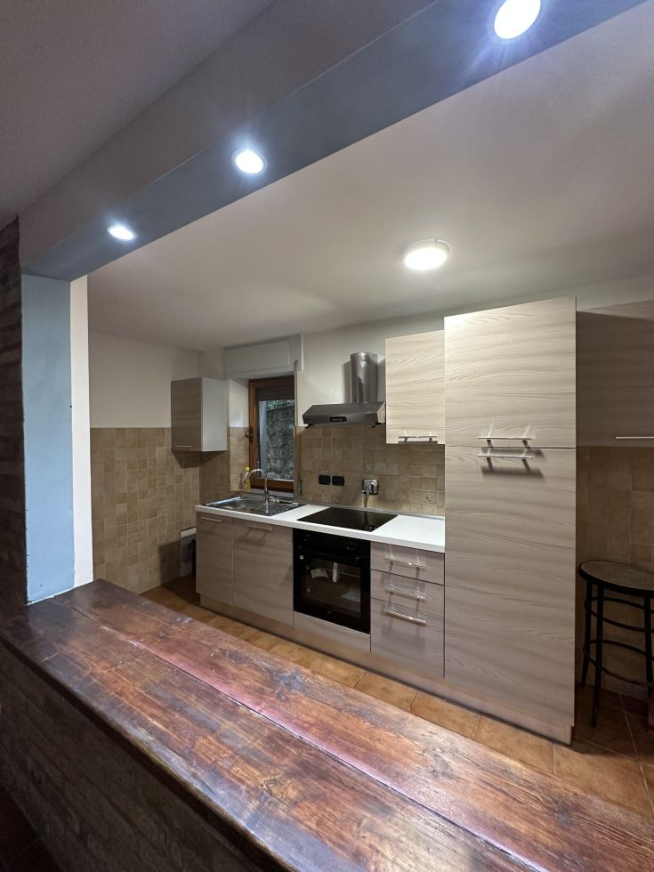 Cucina luminosa e moderna, con finiture semplici e spazi aperti per una maggiore funzionalità.
