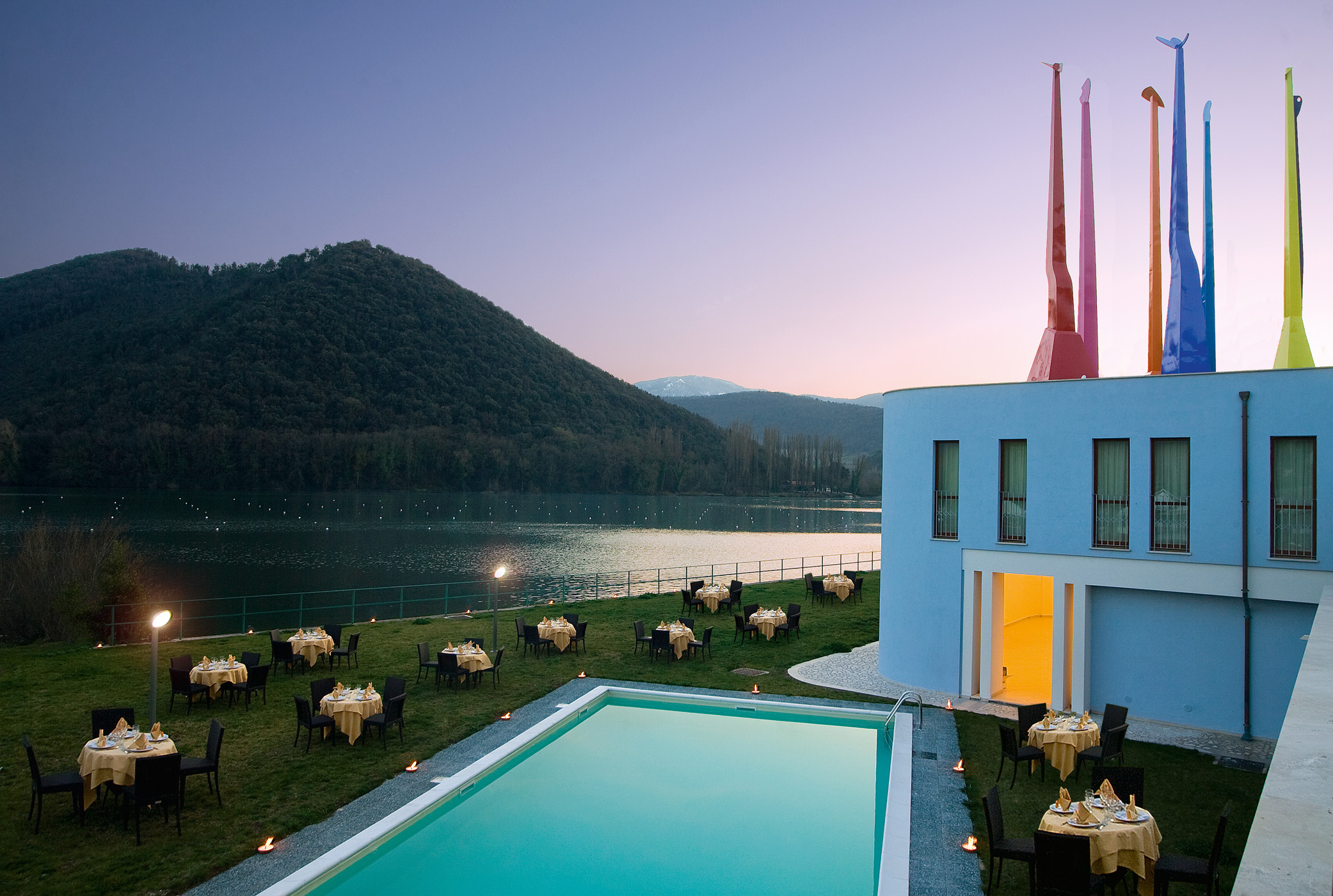 Panorama sul lago di Piediluco, con aree all'aperto attrezzate e una piscina vicino a un edificio.