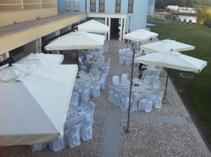Outdoor spaces set up with tables and umbrellas, perfect for an elegant event.