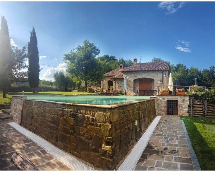 Eine Szene eines Gebäudes mit einem Pool, umgeben von üppigem Grün.