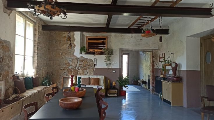 Un ambiente rustico semplice con pavimento in cemento, dettagli in legno e decorazioni sobrie.