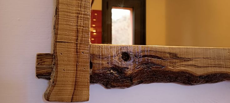 Cornice in legno chiaro, che si integra armoniosamente con un ambiente rustico e accogliente.