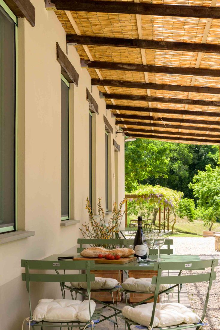 A cozy terrace overlooking a green area, perfect for outdoor dining.