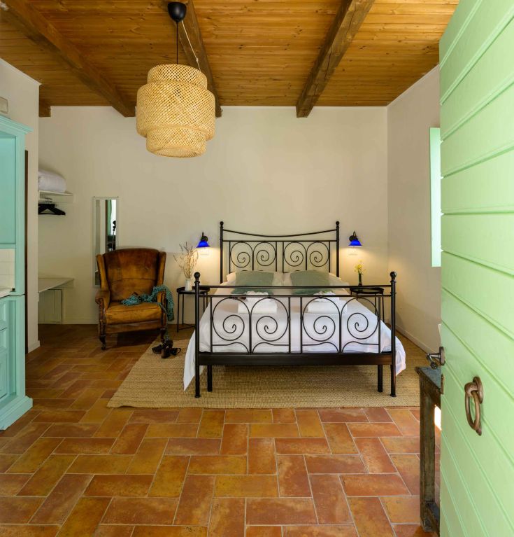 Simple room with a wrought iron bed and rustic style decorations.