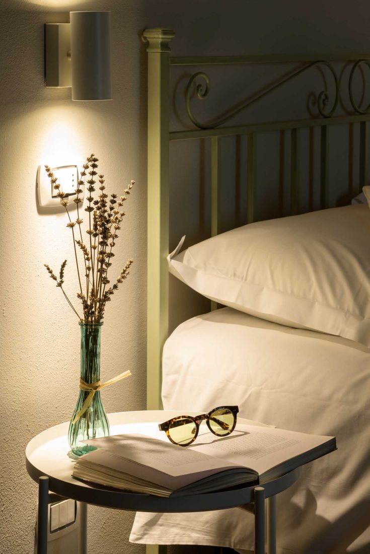 A tranquil area with a vase of dried flowers on a table and sunglasses, perfect for relaxation moments.