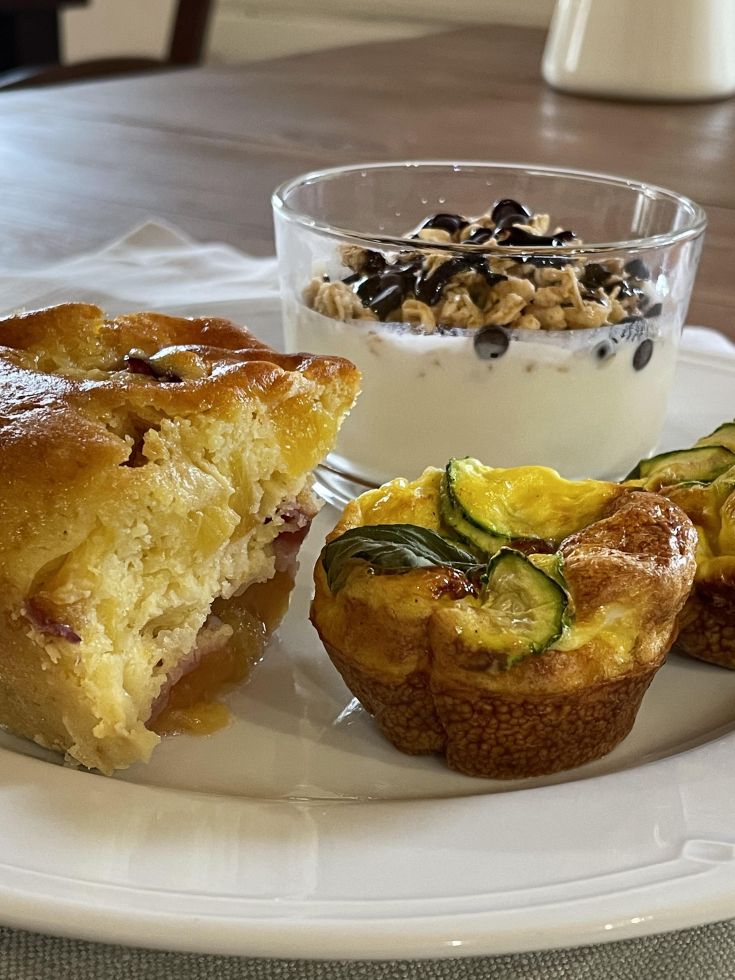 A simple brunch featuring soufflé, yogurt, and fresh pastries.