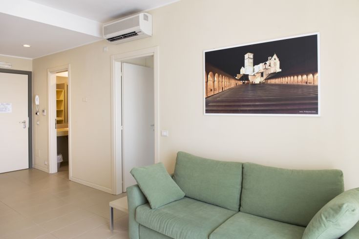 L'intérieur d'un appartement moderne avec un canapé et des éléments décoratifs simples.