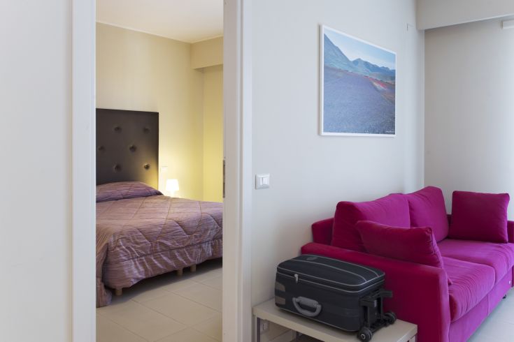 Salon moderne avec lit et canapé, un espace confortable et bien aménagé pour des moments de détente.