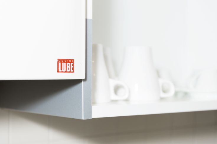 Un panorama d'une cuisine moderne avec des meubles simples et des assiettes blanches à l'affiche.