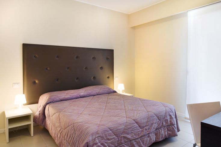 Chambre simple avec un lit double et une décoration contemporaine, parfaite pour un séjour relaxant.