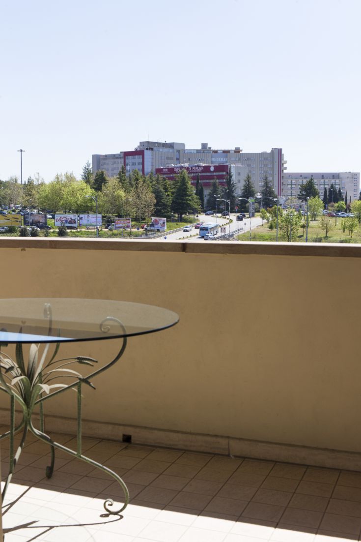 Scène de Pérouse avec un bâtiment moderne entouré d'espaces verts.