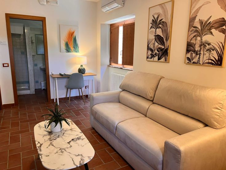 A cozy living room with a sofa and tropical decor, perfect for relaxing moments.