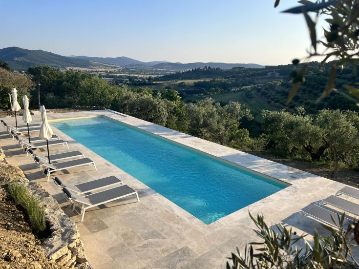 Relaxing moments by the pool in a farmhouse surrounded by gentle hills and olive groves.