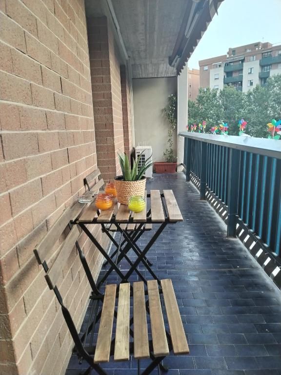 Balcone con tavolo, piante e bevande fresche, adatto per momenti di relax.