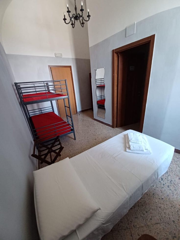 Camera ordinata e accogliente, dotata di letti e arredi pratici per il soggiorno degli ospiti.