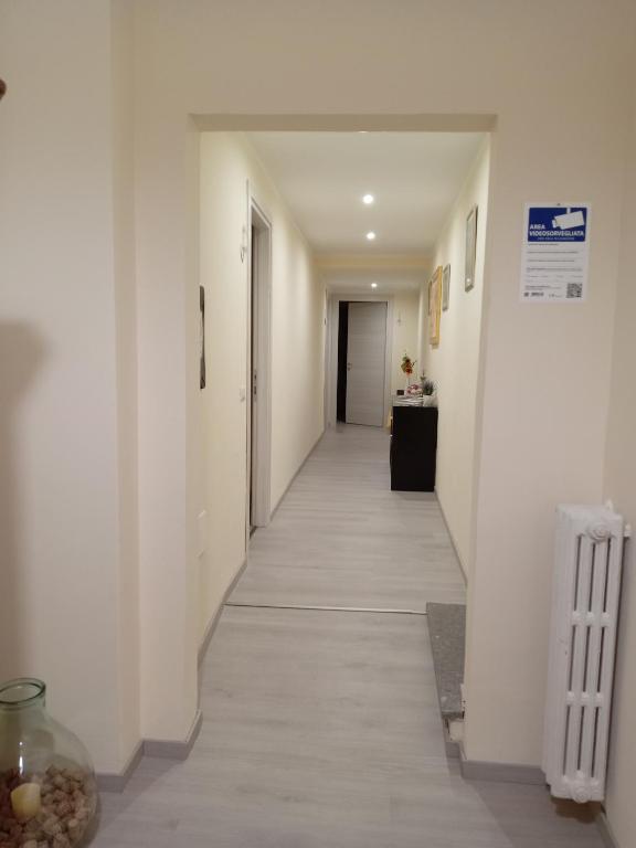 Un corridoio spazioso e luminoso con pareti chiare e un arredamento semplice.
