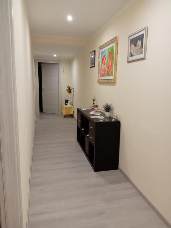 Un corridoio semplice e ordinato, con un arredo sobrio e una piccola console. Luce naturale che entra da una finestra.