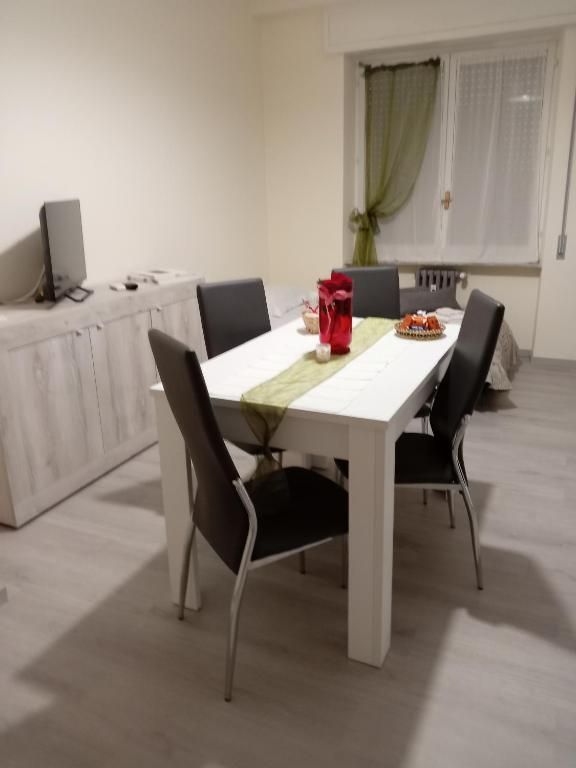 Un'elegante sala da pranzo con tavolo bianco e sedie nere, ideale per pasti in compagnia.