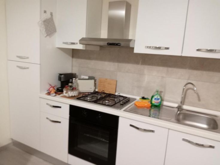 Cucina semplice e funzionale con piano cottura, forno e area per caffè.