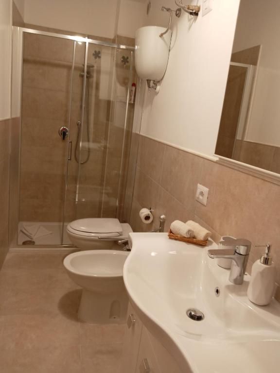 Bagno moderno con doccia, sanitari e rifiniture sobrie.