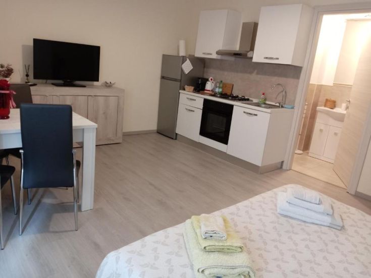 Cucina funzionale con soggiorno luminoso in un appartamento moderno e ben arredato.