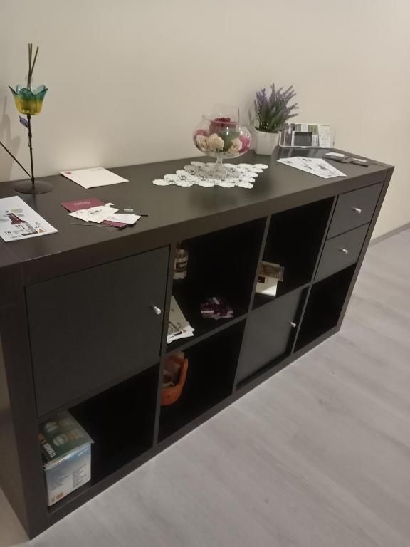 Un mobile semplice con ripiani, adornato con fiori freschi e oggetti di uso quotidiano.