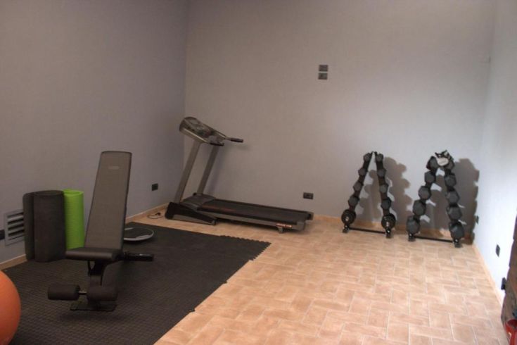 Zone de fitness équipée de tapis de course et de poids pour diverses activités sportives.