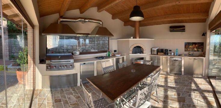 Cuisine moderne et lumineuse, dotée de grandes fenêtres offrant une vue sur le paysage environnant.