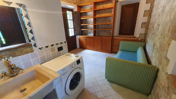 Cozy interior of a cottage featuring a washer, sink, and a living area, perfect for relaxation.