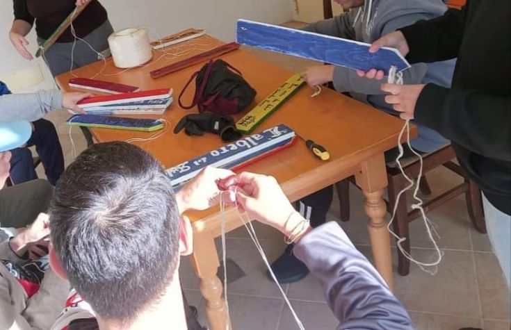A group of people works together, weaving ropes for a shared project in a collaborative environment.