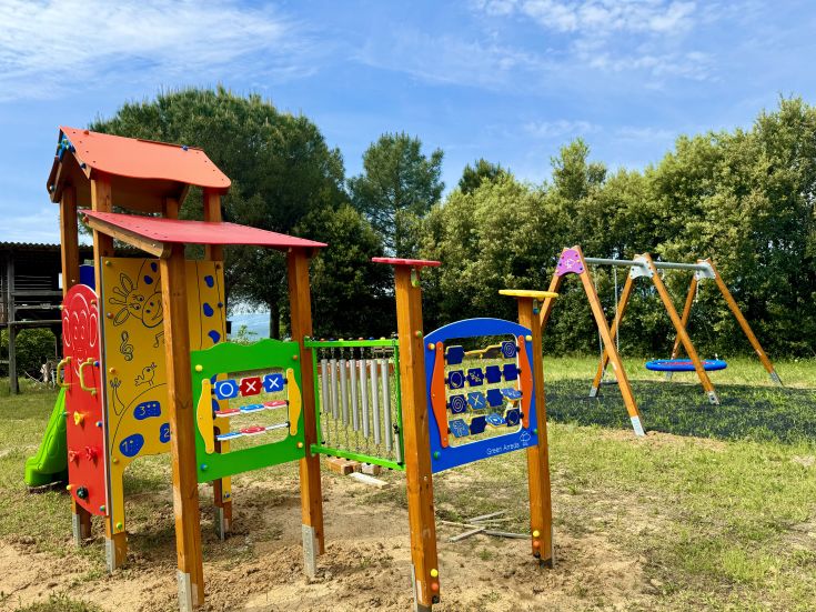 A lively play area surrounded by trees, perfect for the fun of little ones.