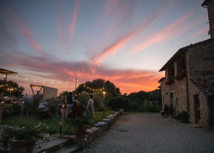 Tramonto sopra Casale Regnano, un agriturismo in Umbria, con luci che si riflettono nel paesaggio e atmosfera accogliente.