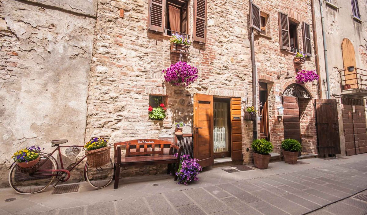 Scena tranquilla con fiori e una vecchia bicicletta in un caratteristico angolo di un borgo umbro.