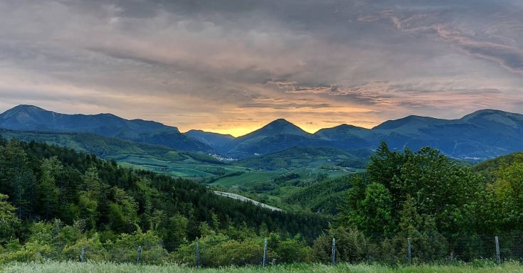Panorama delle colline umbre al tramonto, con riprese di boschi e monti che si tingono di colori caldi.