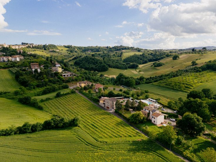 Un panorama che mostra un agriturismo situato tra le colline verdi dell'Umbria.