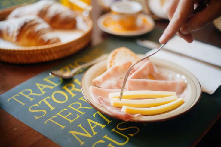 Un piatto assortito con salumi e formaggi locali, ideale per una colazione tradizionale e saporita.