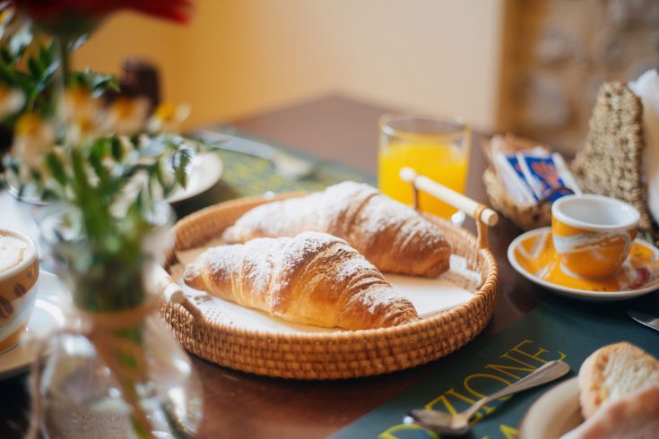 Cornetti sistemati su un tavolo semplice, pronti per un momento di colazione piacevole.