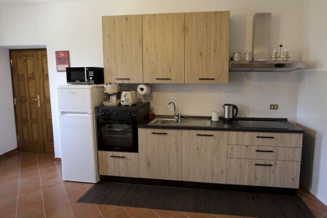 Moderne und funktionale Küche in einer Wohnung in einem historischen Dorf, ausgestattet mit essentiellem Gerät.