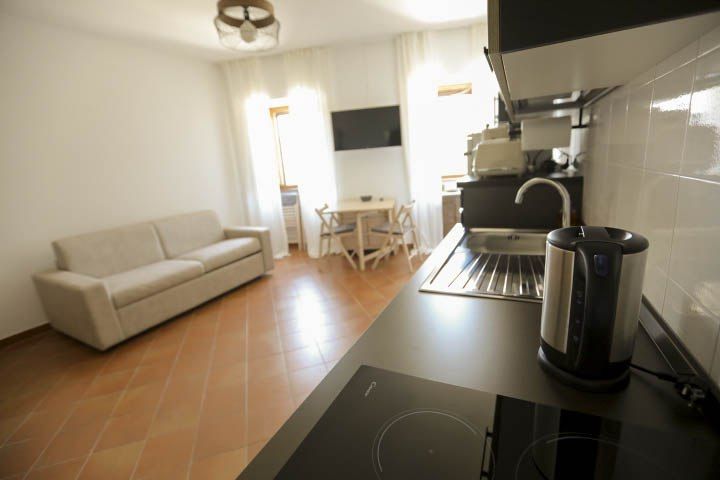 Moderne und gemütliche Küche mit einem Wohnbereich und Sofa, ideal für einen entspannten Moment.