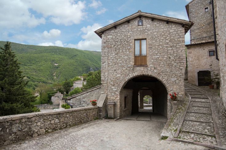 Mittelalterliches Dorf mit Steinbauten, eingebettet in die grünen Berge. Ein ruhiger Ort mit historischem Wert.