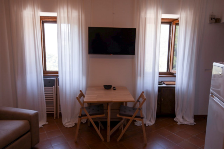 Helles und komfortables Apartment mit Blick auf die Berge, ausgestattet mit einer Küche und einem Fernseher.