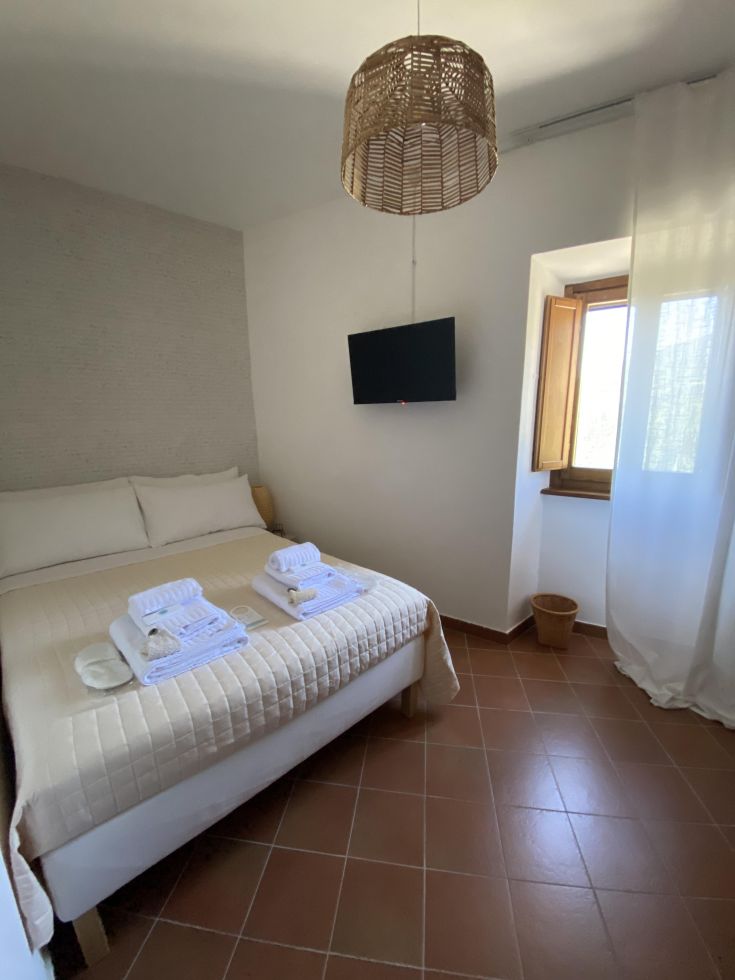 Gut ausgestattetes Schlafzimmer in einer Wohnung, mit Bettwäsche und verschiedenen Annehmlichkeiten.