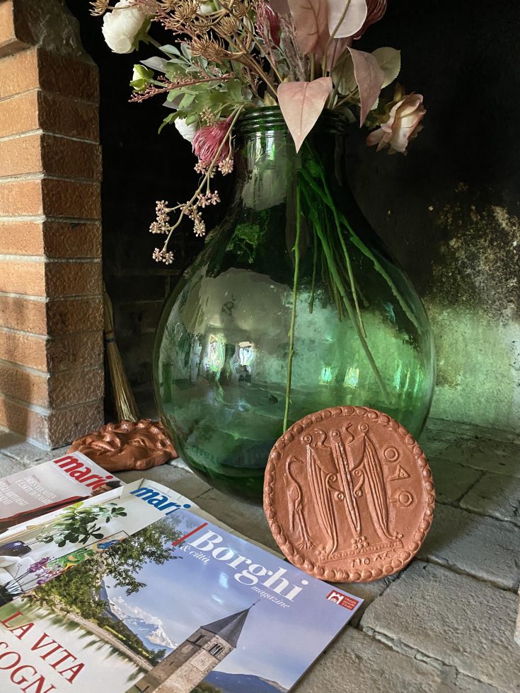 Ein komfortabler Raum mit üppigen Pflanzen, getrockneten Blumen und Zeitschriften, ideal für ruhige Momente.