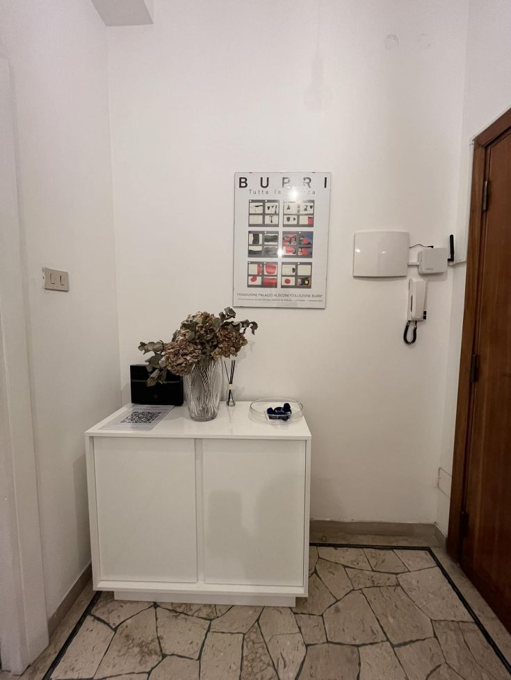A cozy entrance featuring a white furniture piece and floral decorations, ideal for welcoming guests.