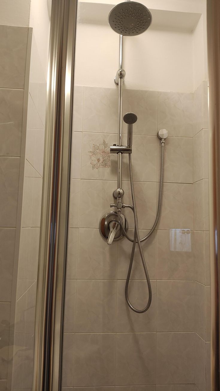 Moderne Keramikdusche mit Duschkopf und Mischventil, in einer gepflegten und komfortablen Umgebung.