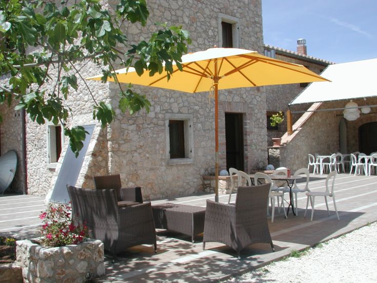 Ein bequemer Außenbereich mit Stühlen und einem gelben Sonnenschirm, perfekt zum Entspannen.