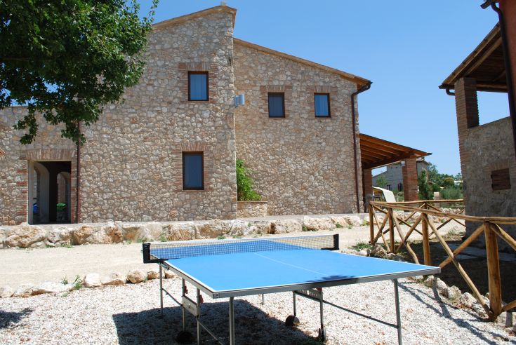 Ein ländliches Agriturismo, umgeben von Natur, mit einem Tischtennistisch im Freien.