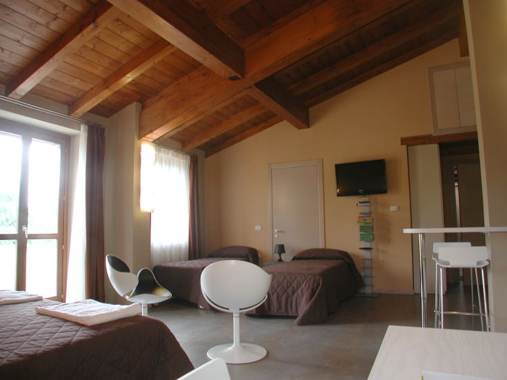 Gemütliches Zimmer mit Holzdecke und natürlichem Licht, perfekt für einen entspannten Aufenthalt.