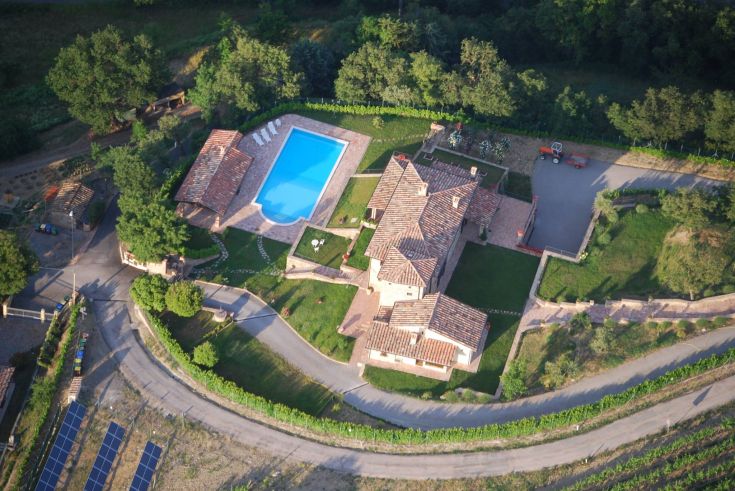 18th century building with a pool, located among vineyards and surrounded by a large green area.